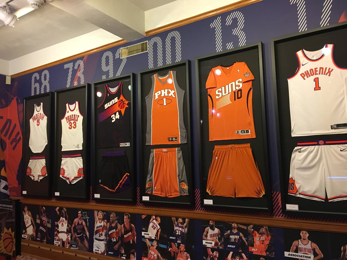 A wall showcasing Phoenix Suns uniforms over the years.