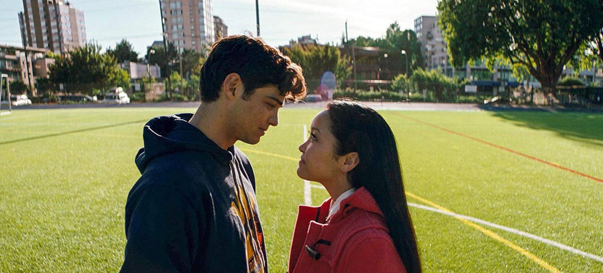 Noah Centineo and Lana Condor look at each other on a lacrosse field, screencap from the movie.