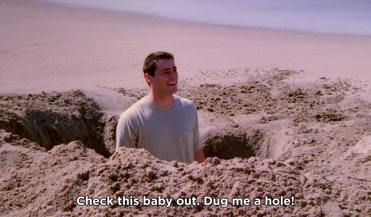 Joey from “Friends” in a giant hole he dug at the beach. Caption says “Check this baby out. Dug me a hole!”