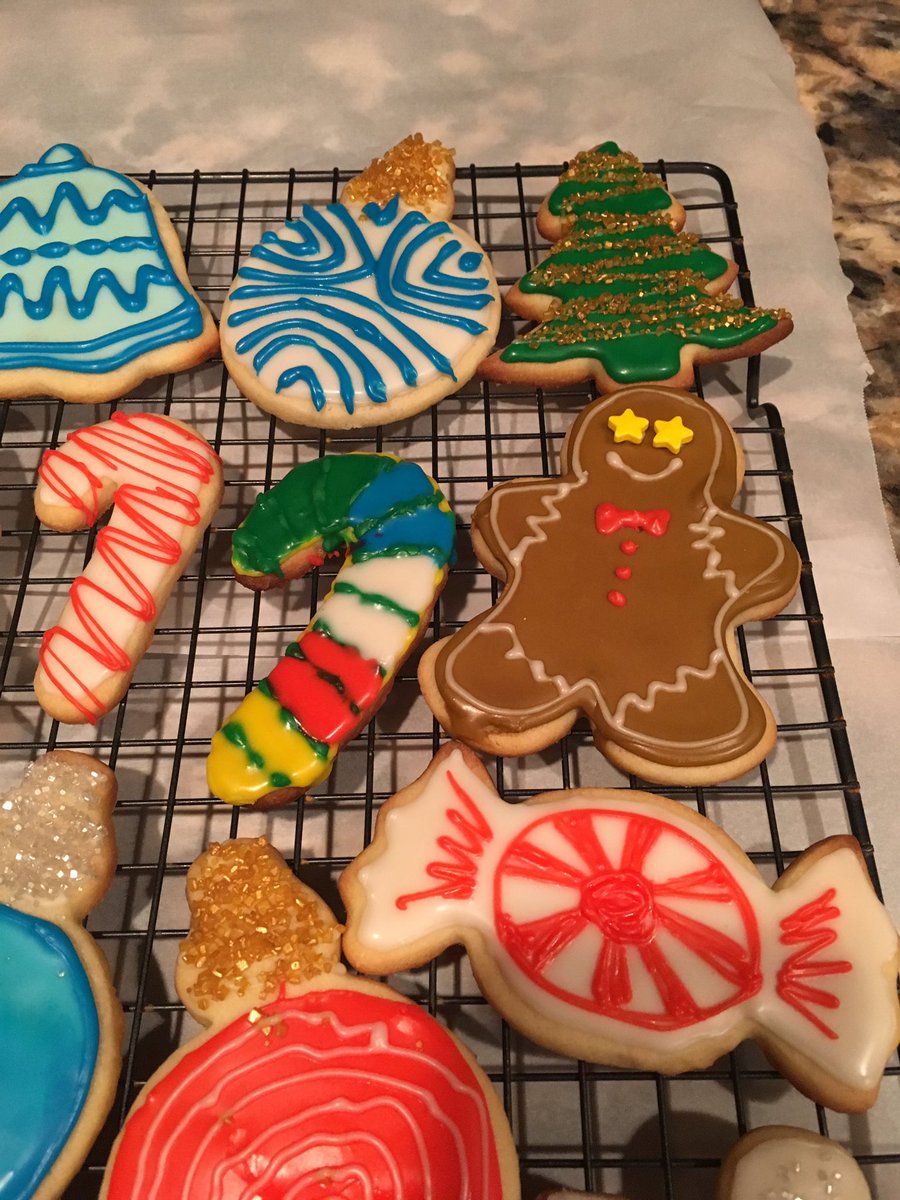 A candy cane cookie with yellow, red, green, blue, and white striped icing