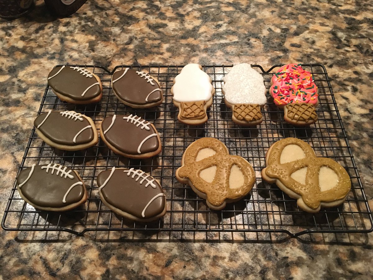 Decorated sugar cookies of footballs, ice cream cones, and salted pretzels.