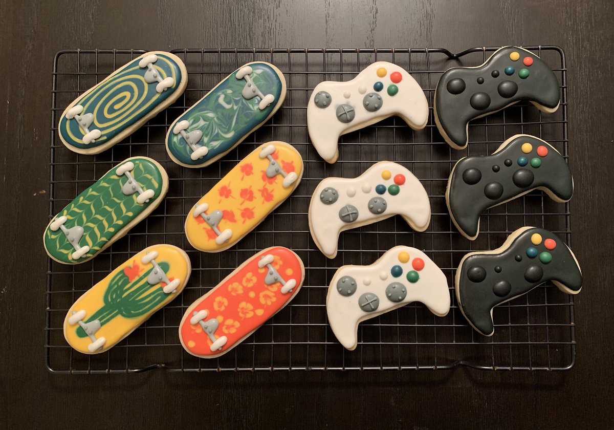 Sugar cookies decorated with colored icing: Xbox game controllers and skateboards with patterned decks.