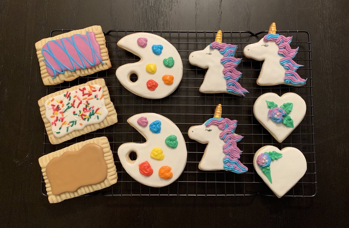 Decorated iced sugar cookies in the shapes of unicorns, artist palettes, hearts, and pop tarts.