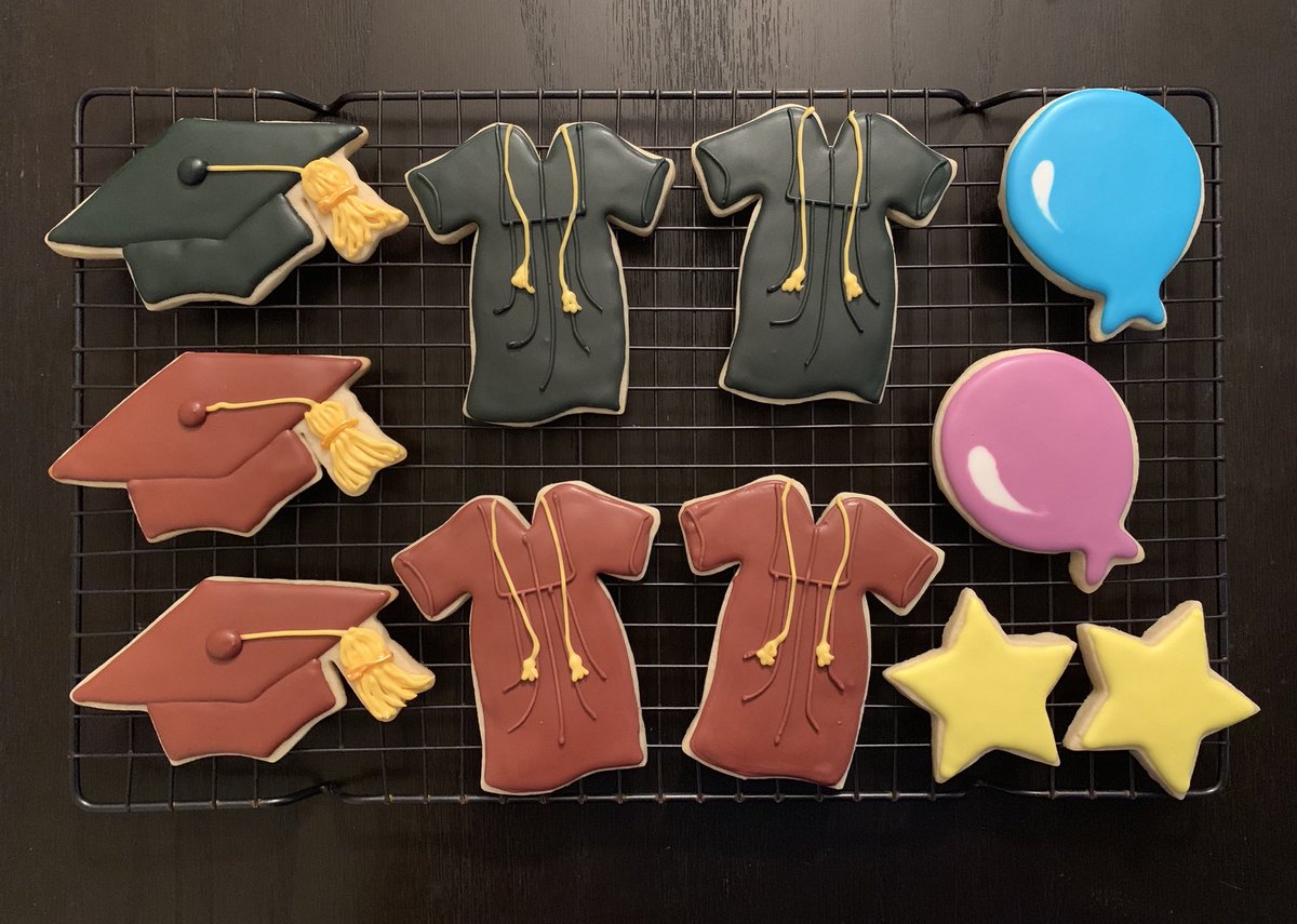 Decorated sugar cookies in the shapes of graduation caps and gowns, balloons, and stars.