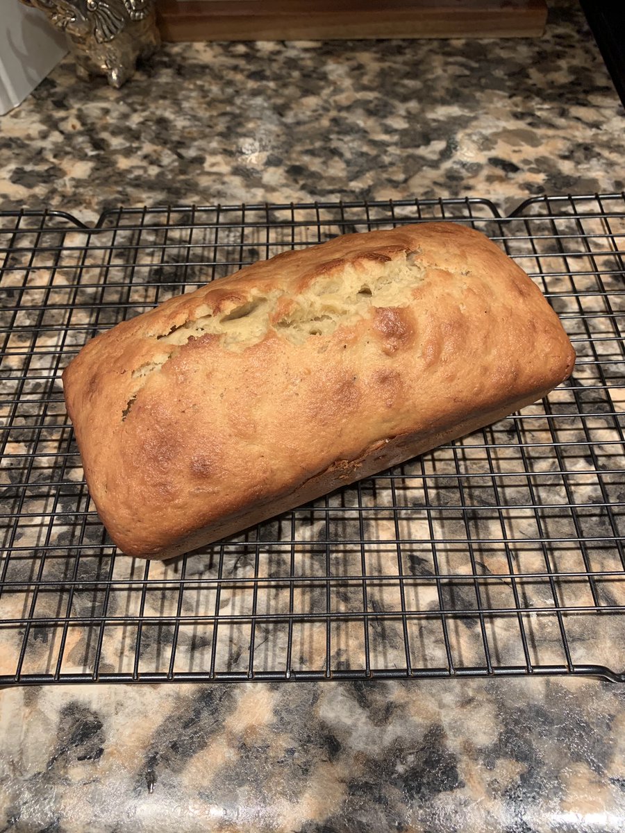 Freshly baked loaf of banana bread on a cooling rack.