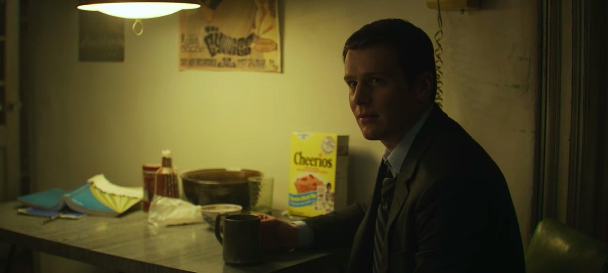 Holden from Mindhunter sitting at a table with a perfectly placed and lit box of Cheerios
