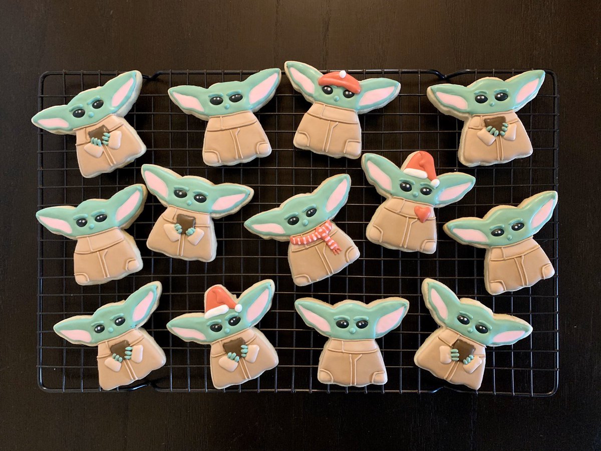 Decorated cookies of baby Yoda, some with Santa hats.