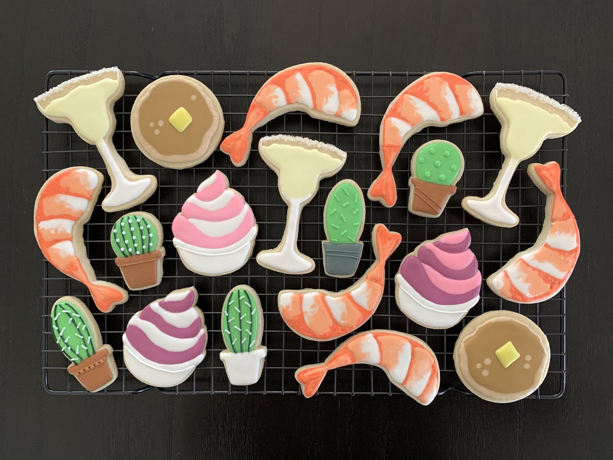 Decorated sugar cookies in the shapes of margaritas, shrimp, pancakes, frozen yogurt, and potted cacti.