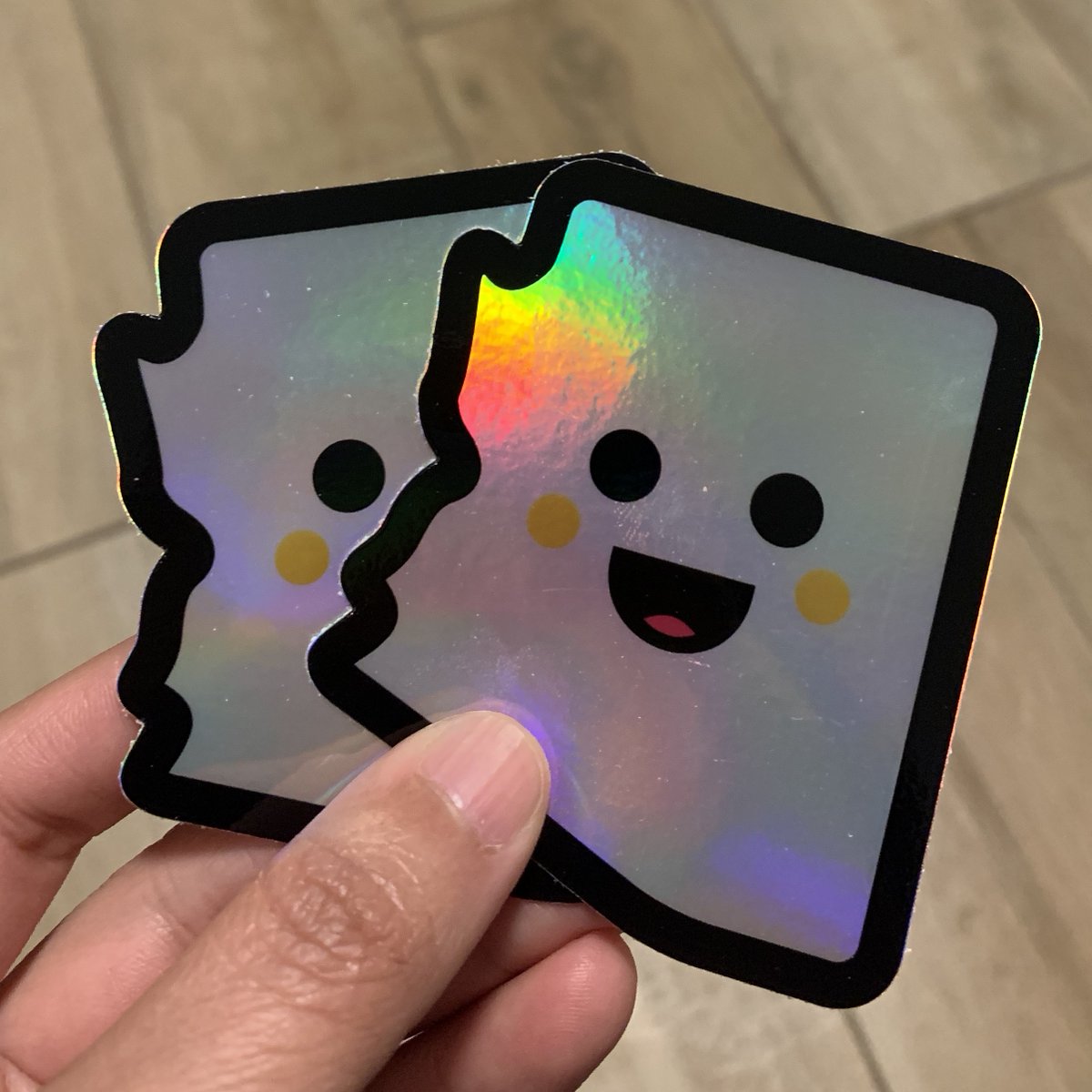 Iridescent stickers shaped like Arizona with happy smiling faces.