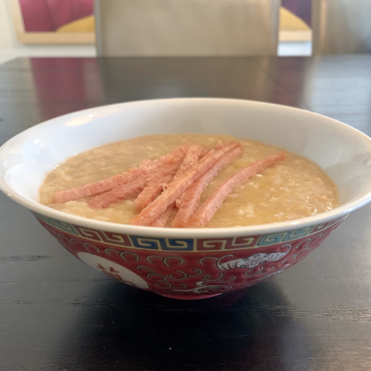 Bowl of rice porridge with slices of Spam on top.