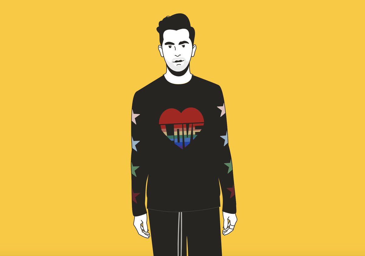 David Rose in a black sweater with a rainbow colored heart that says LOVE on the chest. Multi-colored stars line the sleeves.