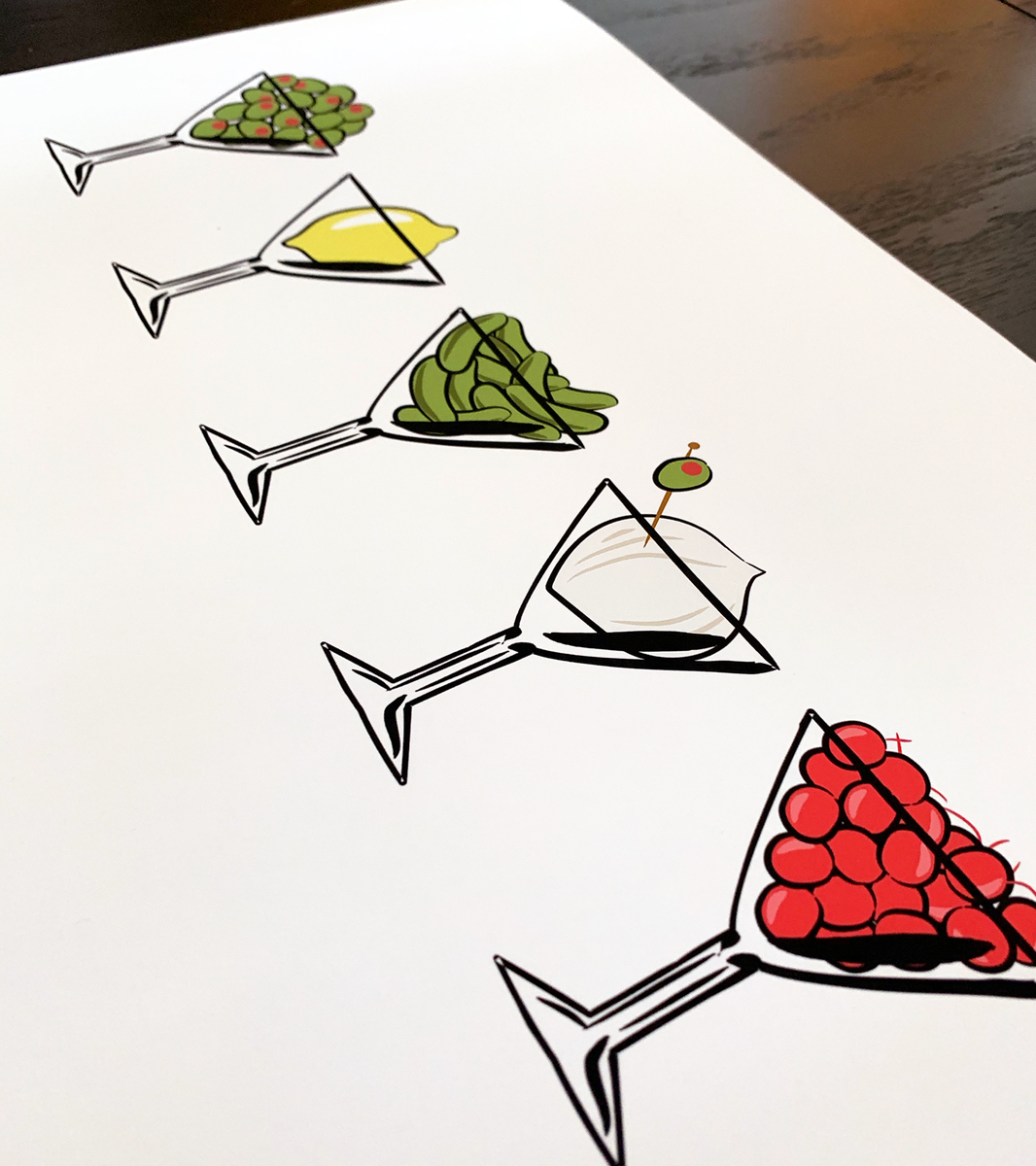 Close up angle shot of a print featuring five martini glasses filled with olives, a lemon, gherkins, an onion, and cherries.