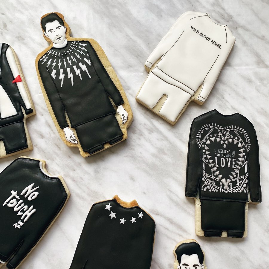 Sugar cookies decorated like David Rose from Schitt’s Creek in various sweaters.