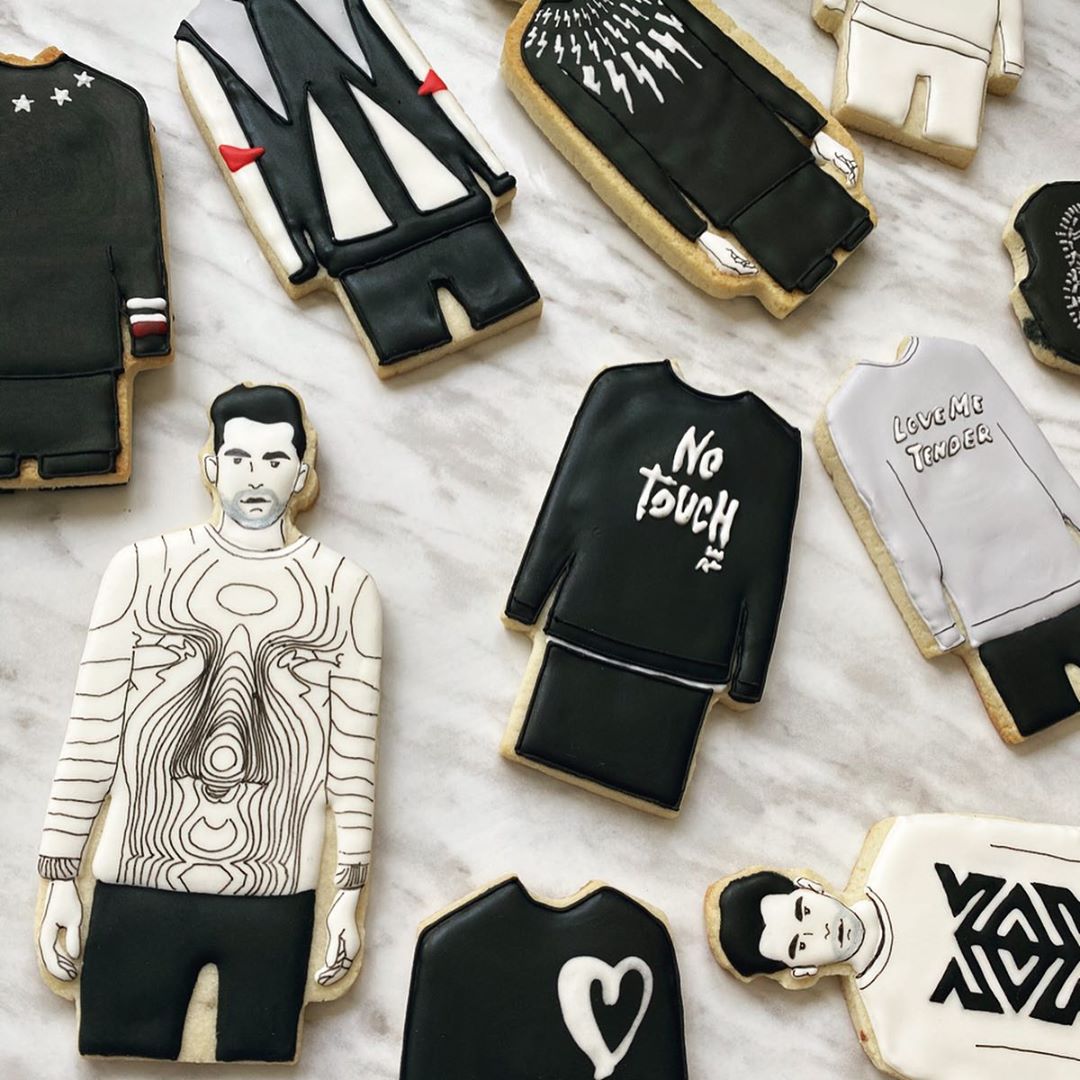 Sugar cookies decorated like David Rose from Schitt’s Creek in various sweaters.