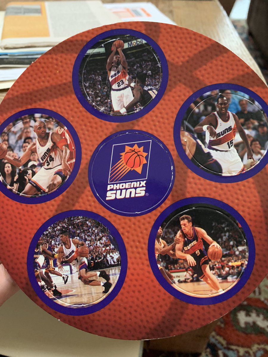 A cardboard circle with perforated POGs with pictures of old Phoenix Suns players like Kevin Johnson and Charles Barkley.