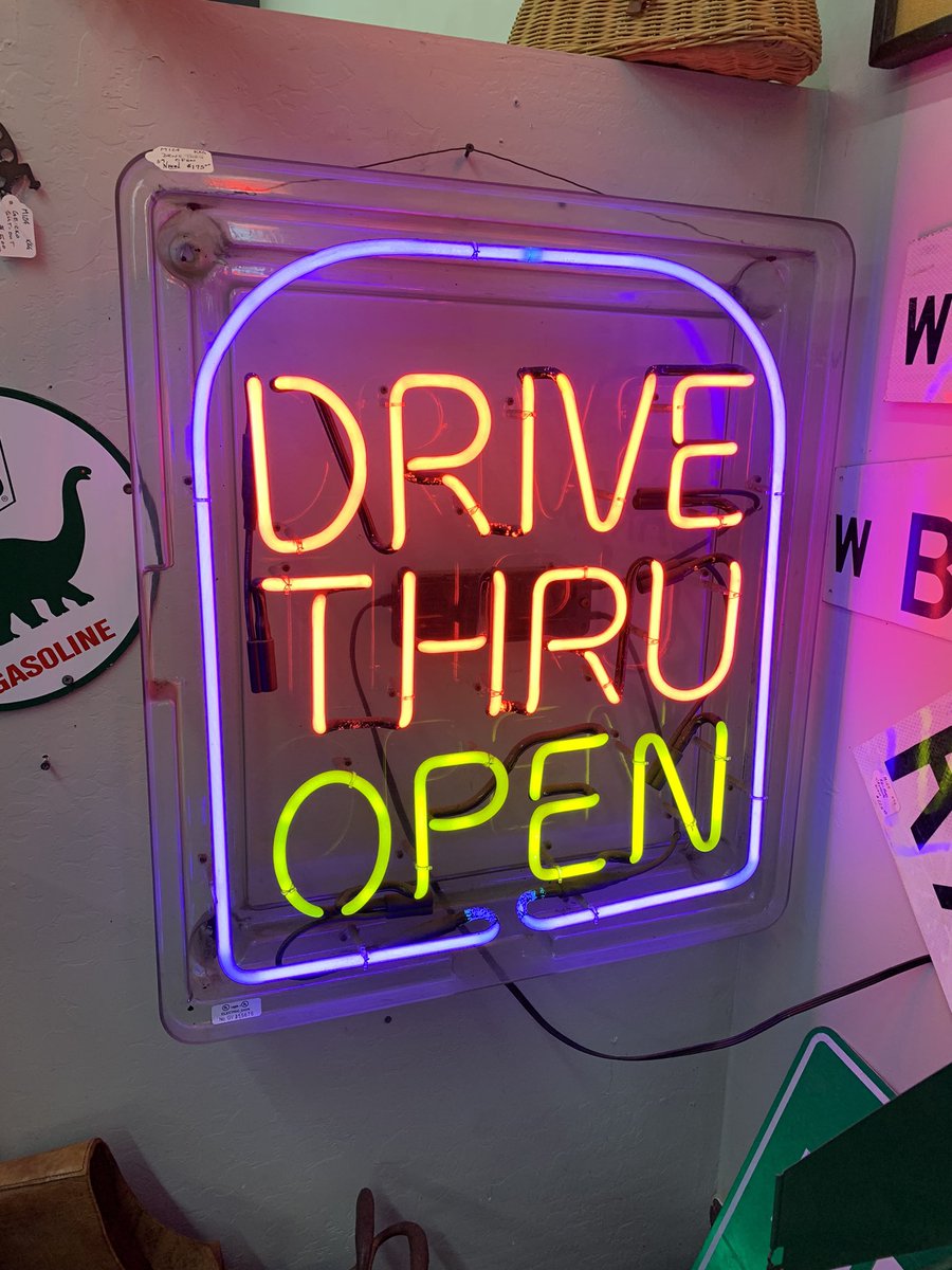 Neon sign that says “drive thru open”