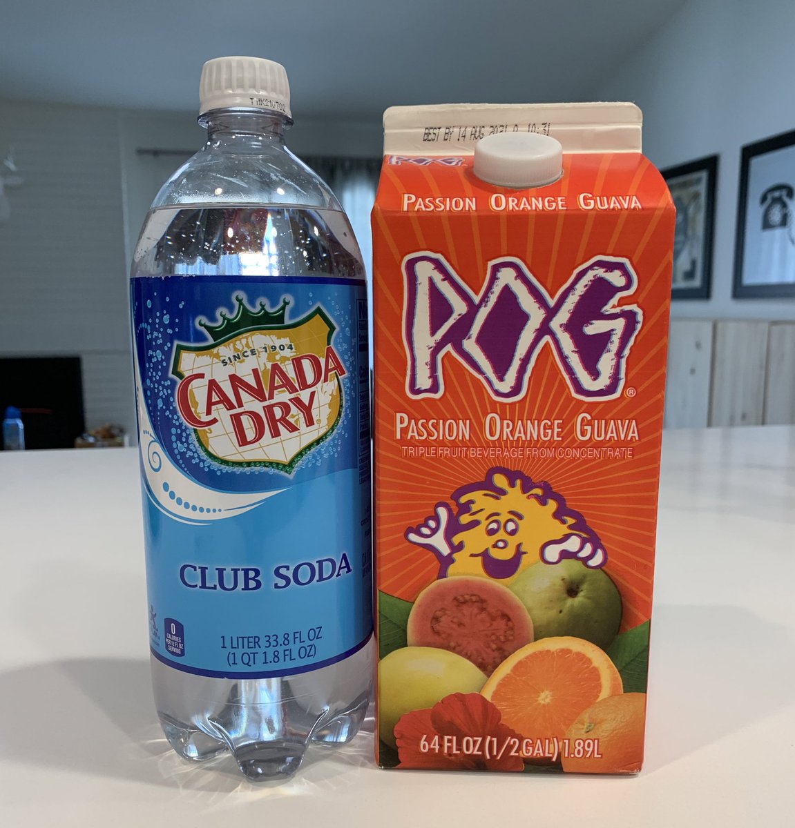 A bottle of club soda and a carton of POG juice