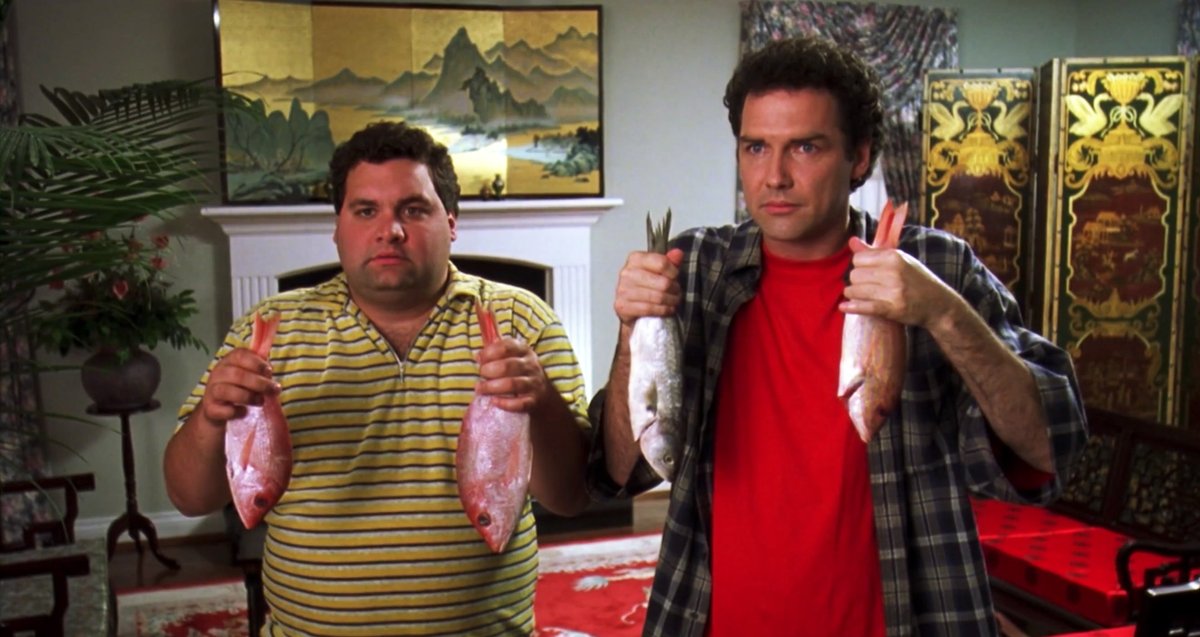 a shot from Dirty Work: Norm Macdonald and Artie Lange are stunned silent, both holding a fish in each hand