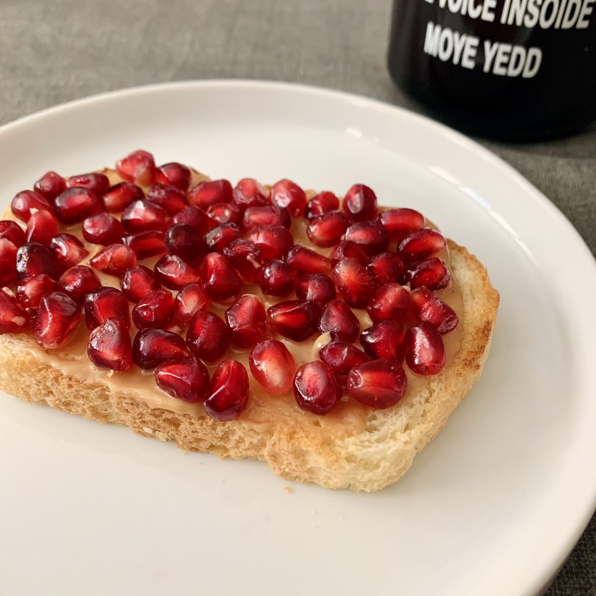 Toast topped with peanut butter and pomegranate seeds