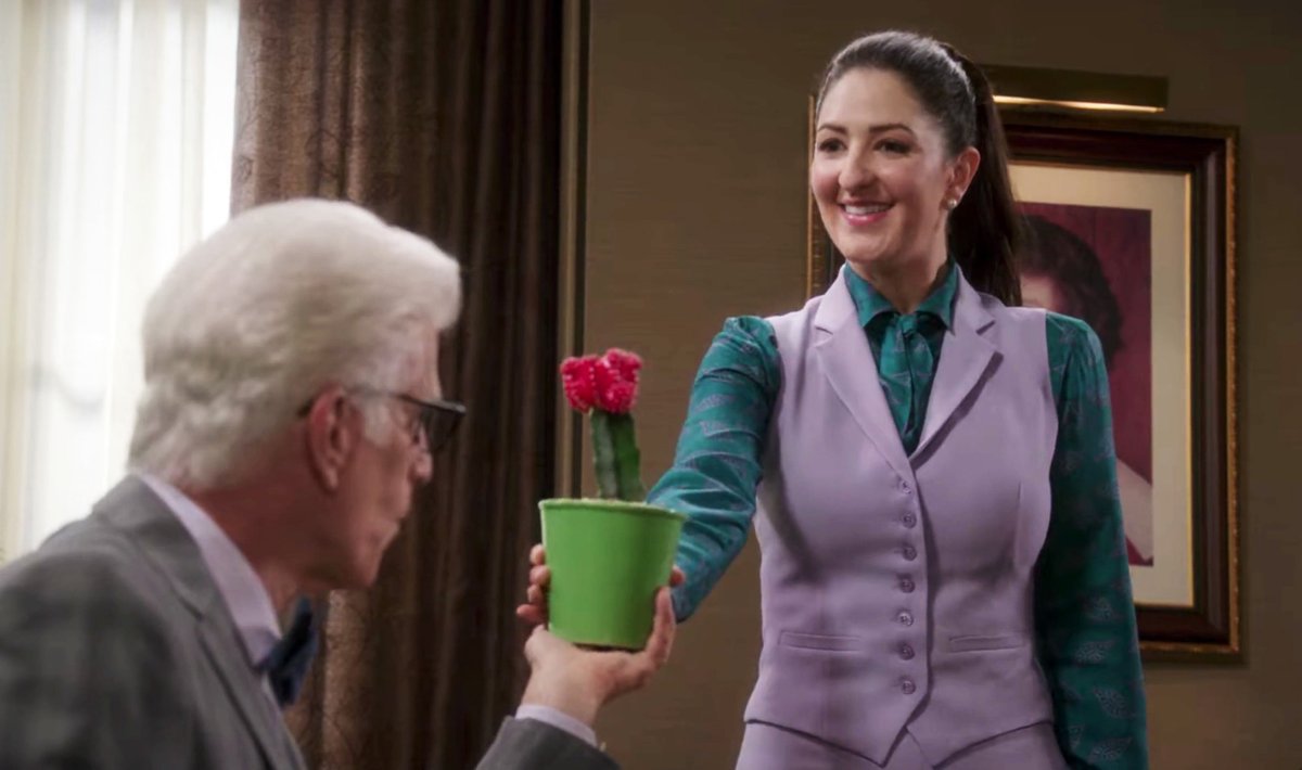 a scene from The Good Place showing Janet handing Michael a small potted cactus