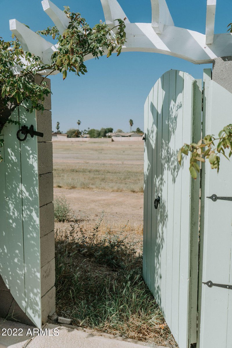 the gate is open to show some clever planning: it’s still a standard-sized gate and the round sides of the hobbit door are attached to the cement pillars