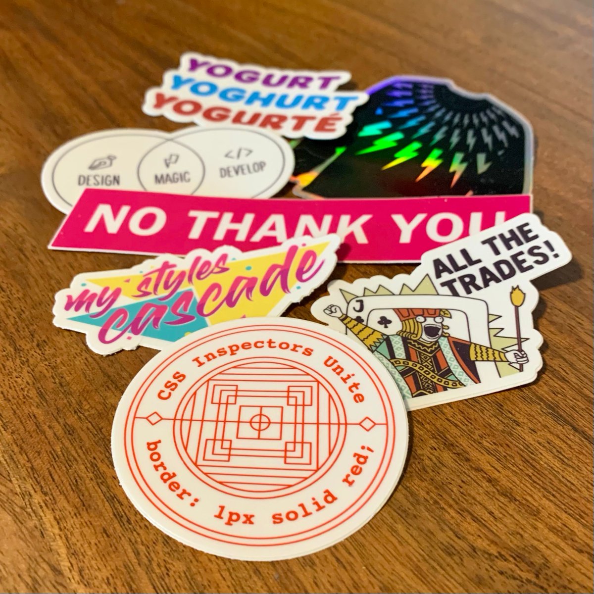 a little pile of vinyl stickers including ones for CSS developers, jacks of all trades, and fans of Schitt’s Creek + The Good Place