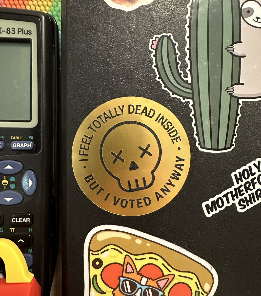 round metallic sticker with a skull that says “I feel totally dead inside but I voted anyway”