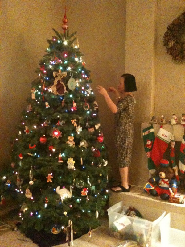 tiny Asian lady next to tall Christmas tree