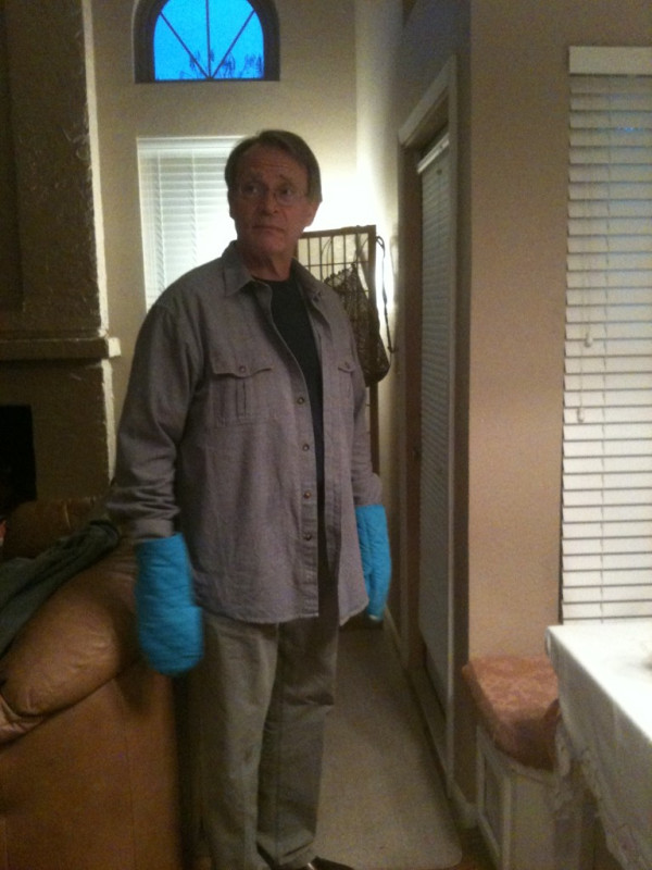 man with bright blue oven mitts on both hands