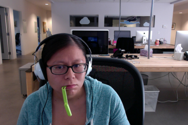 the author at her desk with a green chip clip hanging out of her mouth