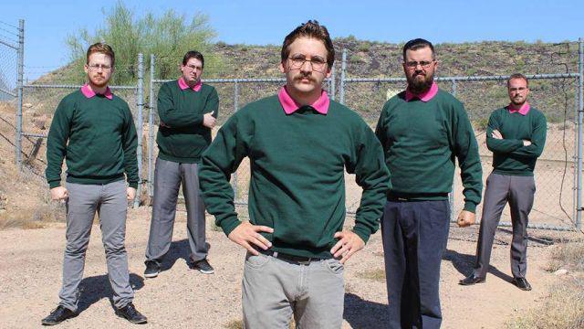 five metal dudes all dressed in green sweaters over pink collard shirts like Ned Flanders