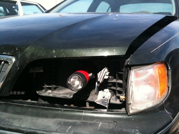 flashlight stuck inside a broken headlight
