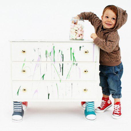 dresser with the furniture feet next to a kid wearing high-tops too