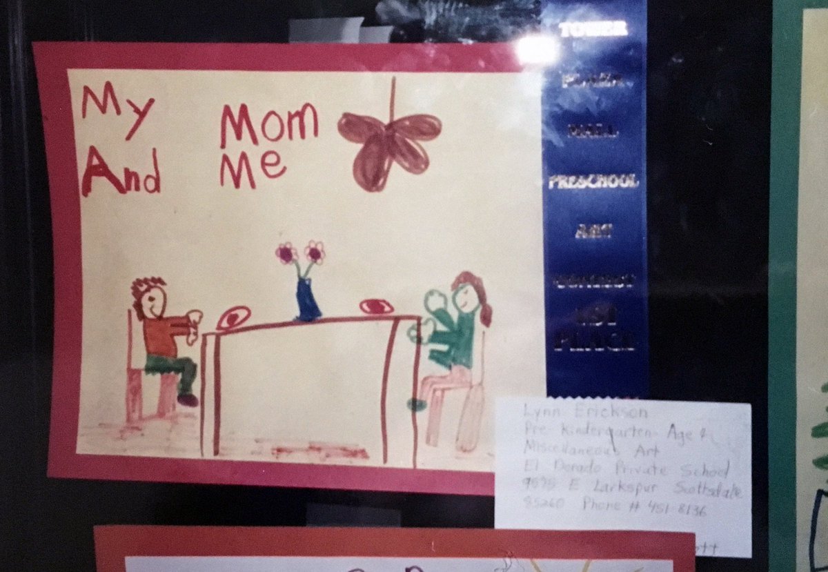 close-up of the drawing of two people at a dining table captioned “My Mom and Me”