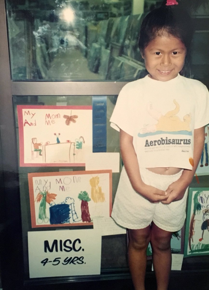 young Lynn standing next to a drawing and first place ribbon