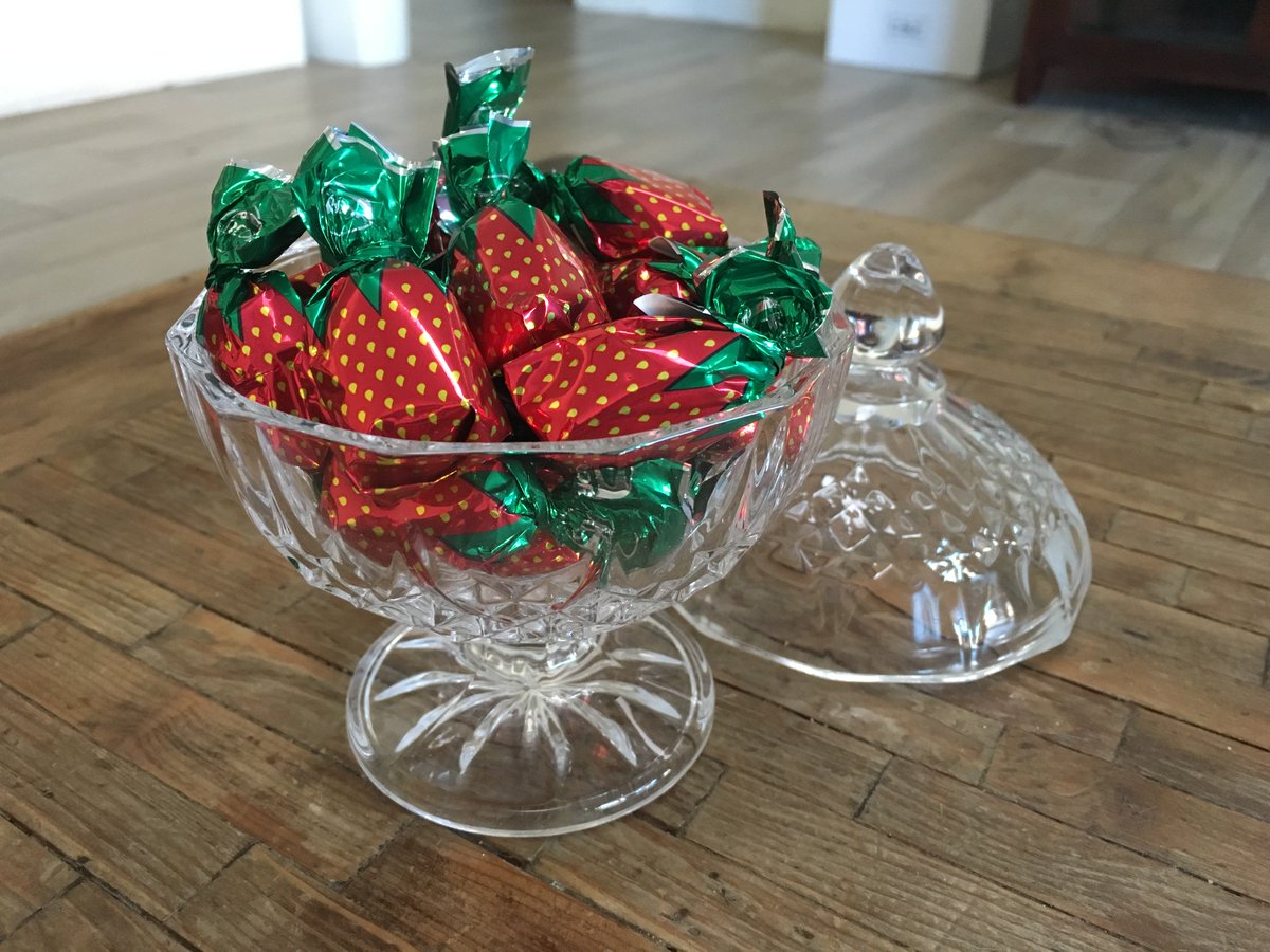 glass candy dish filled with hard candies wrapped to look like strawberries