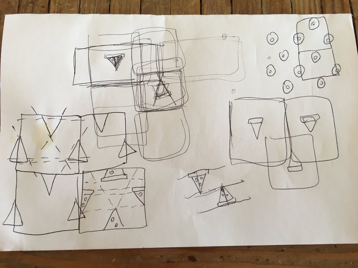 Pen and paper sketches trying to figure out how to make a repeatable pattern of pizza slices, small diet soda stain.