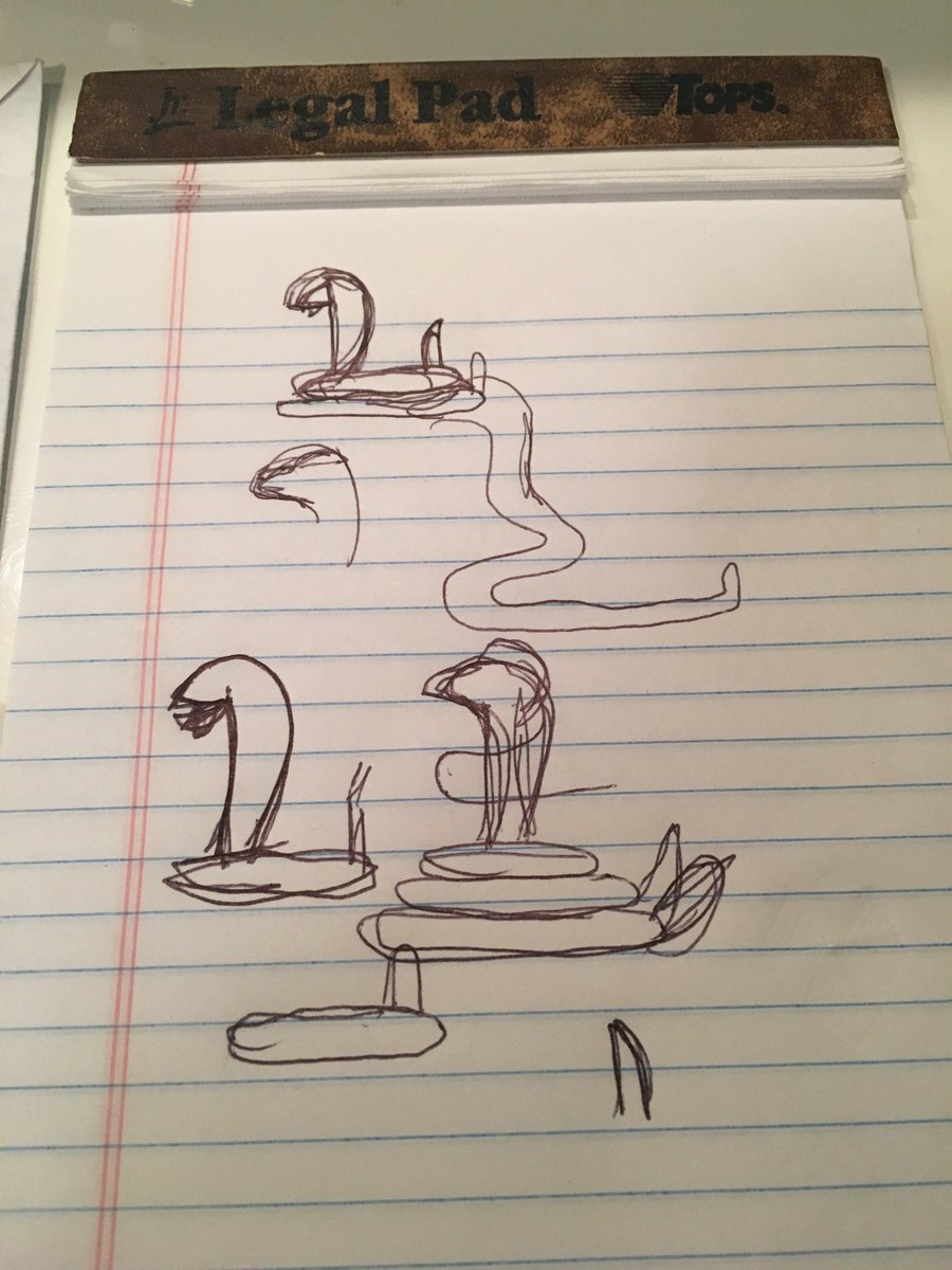 Pen sketches of cobras on a lined notepad.