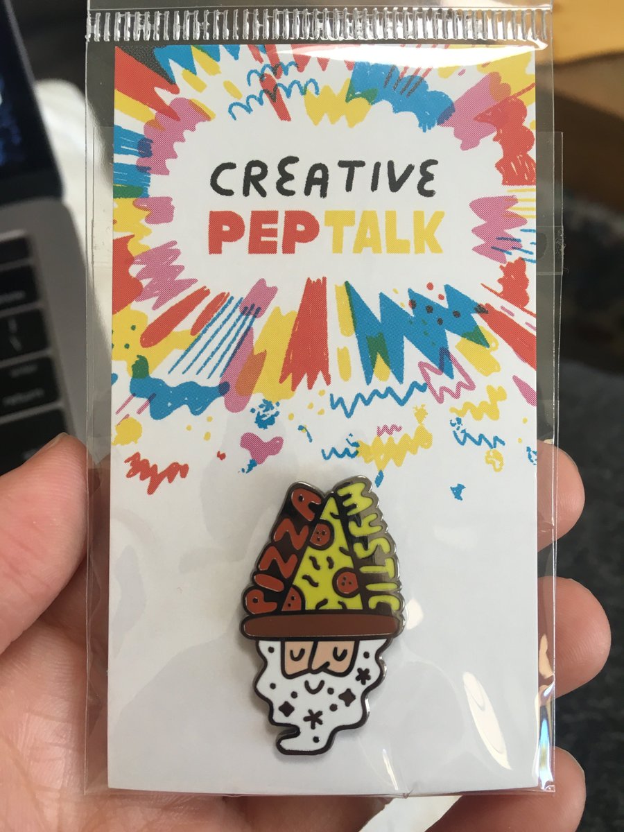 Enamel pin of a bearded wizard whose hat is a slice of pepperoni pizza. It says "Pizza Mystic" and his beard is sparkling.
