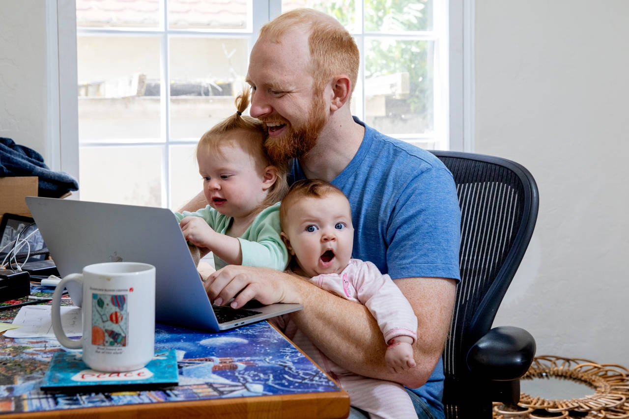 man at a computer with two kids on his lap