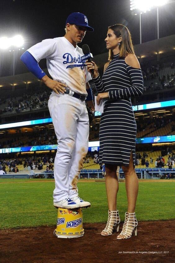 baseball player being interviewed by a taller woman so he is standing on an overturned bucket so he is taller