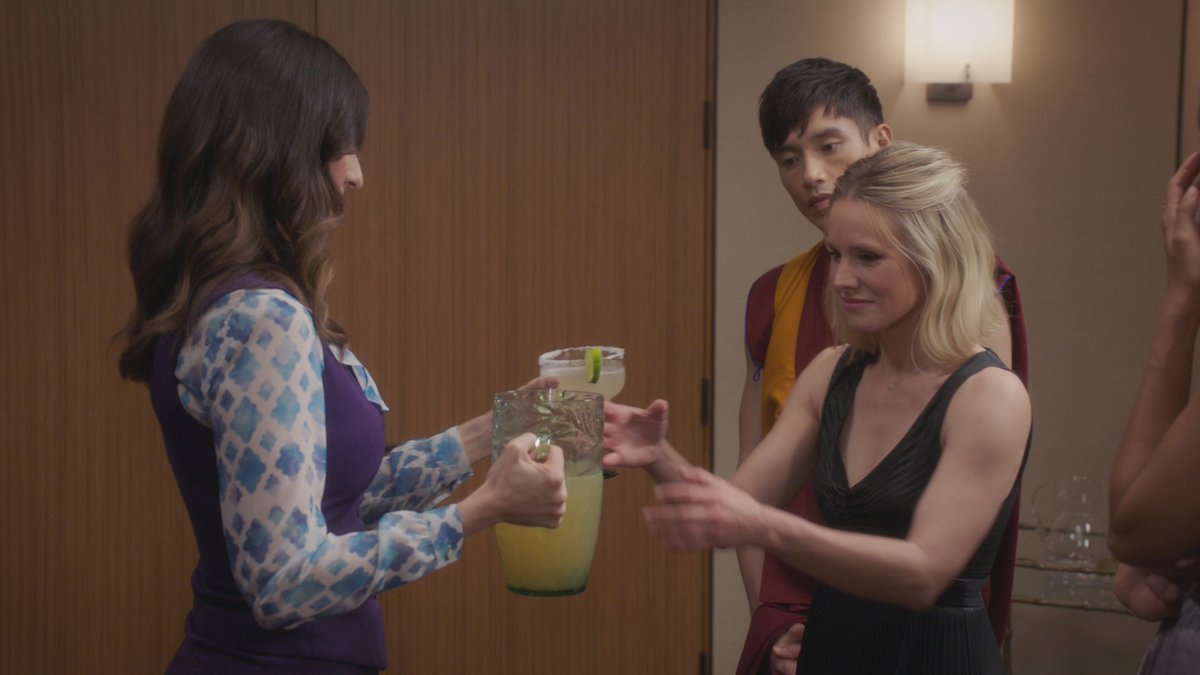 Janet from the Good Place handing Eleanor a pitcher of maragaritas