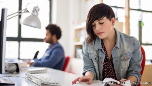 woman looking through paperwork at an office